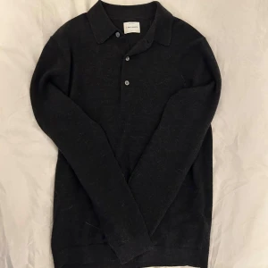 Svart grå tröja i merinoull från A Day's March - Säljer en stilren svart grå tröja i merinoull från A Day's March. Storleken är S Sitter som de ska i storleken
