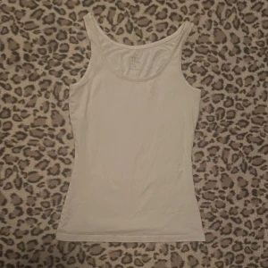 Vit linnetopp  - Säljer en enkel och stilren vit linnetopp från lager 157. Har två små hål vid ryggen och ett vid höften, annars i bra skick.