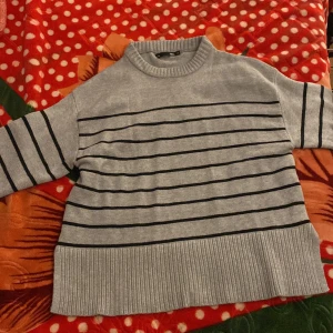 Grå och svart randig tröja från 157 - Säljer en superfin grå tröja med svarta ränder från 157. Den är i storlek XS och har en skön, ribbad kant vid ärmslut och nederkant. Perfekt för både höst och vår! 🖤