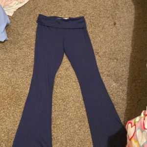 Mörkblå byxor från H&M - Säljer ett par mörkblå byxor från H&M i storlek 152. De är superbekväma och har en loose passform med en bred midja som kan vikas ner. Perfekta för en avslappnad dag hemma eller ute på stan. Materialet är mjukt och stretchigt, vilket gör dem sköna att bära hela dagen.