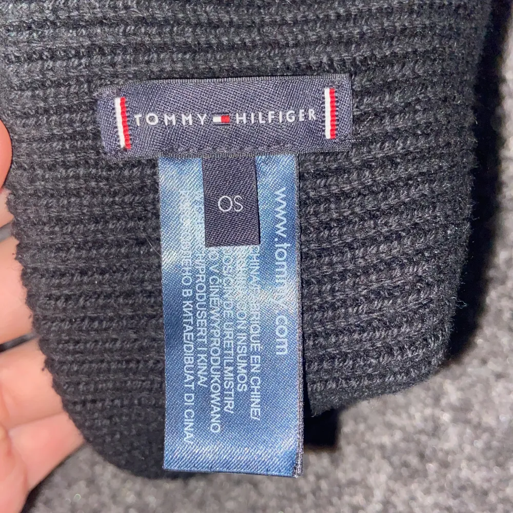 Snygg svart stickad mössa från Tommy Hilfiger med deras ikoniska logga broderad framtill. Perfekt för att hålla värmen under kalla dagar. Den ribbade designen ger en stilren look som passar till allt. Ett måste för vintern! (Accepterar endast Swish pga lurendrejerier) (Checka även in andra kläder på min profil och köp tillsammans för ett rabatterat pris). Asusteet.