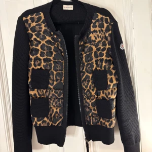 Leopardmönstrad jacka från Moncler - Säljer nu min leopard jacka från Moncler,                 det är en storlek L men passar mig perfekt som har XS/S                                                                                                Pris är diskuterbart.                                 Leopardmönster och svarta stickade ärmar. Jackan har en dragkedja framtill och ribbade detaljer. Perfekt för att sticka ut med stil.