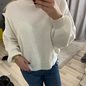 Vit stickad tröja - Säljer en stilren vit stickad tröja med hög krage och långa ärmar. Perfekt för kyliga dagar och enkel att matcha med jeans eller kjol. Tröjan är ribbad🤍