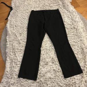 Svarta kostymbyxor från BikBok - Snygga svarta kostymbyxor från BikBok i storlek 44. Byxorna har en klassisk design med raka ben och diskreta fickor baktill. Perfekta för en stilren look. Säljer dessa då dem är förstora för mig men älskar dem oxh köpte nya i mindre storlek! 