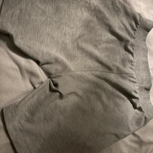 Grå shorts från McKenzie - Säljer ett par bekväma grå shorts från McKenzie. De har en elastisk midja och är perfekta för en avslappnad stil. Passar bra till både träning och vardag.