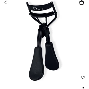 Ögonfransböjare från Dior - Elegant svart ögonfransböjare från Dior med bekväma handtag och en stilren design. Perfekt för att skapa vackert böjda fransar med ett professionellt resultat. 