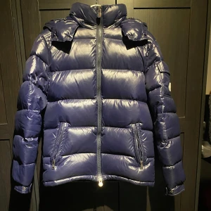 Blå pufferjacka från Moncler - Säljer en snygg blå pufferjacka från Moncler. Jackan är använd sen förra vintern men har inga tecken på användning eller slitning.Perfekt för kyligare väder, säljs p.ga den är för liten