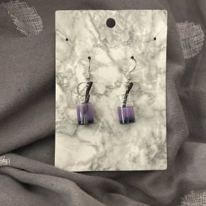 Lila örhängen med boba-design - Unika örhängen i form av små boba-te koppar med lila dryck och svarta pärlor som boba. Perfekta för att ge en lekfull touch till din stil. Niclelfria och med pluppar