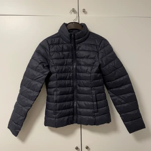 Mörkblå quiltad jacka från ONLY - Säljer en snygg mörkblå quiltad jacka från ONLY i storlek M. Jackan är perfekt för höst och vår eller som mellanlager under skidjacka. Den är helt ny med prislapp kvar. Säljer eftersom den va för liten för mig. 💕😊 den kostade 529 kr. 