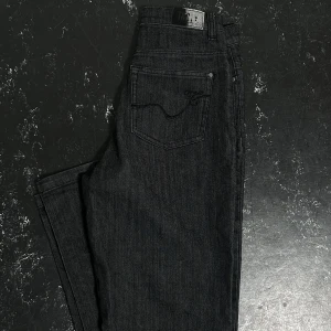 Svarta jeans - Snygga svarta jeansbyxor med fin detalj på fickorna. Innerbenslängd: 80cm. Midjemått: 33cm