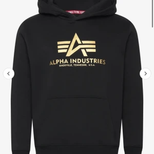 Svart hoodie från Alpha Industries - Snygg svart hoodie från Alpha Industries med guldig logga på bröstet. Säljes då jag fick fel storlek och ej orkade lämna tillbaks. Helt ny 