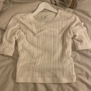 Vit stickad tröja från JDY - Säljer en superfin vit stickad tröja från JDY. Den har ett snyggt hålmönster och trekvartsärmar, perfekt för vår och sommar. Tröjan är i mycket bra skick och passar både till vardags och lite finare tillfällen. Perfekt att matcha med jeans eller kjol!