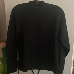 Svart stickad tröja HM - Säljer en stilren svart stickad tröja med långa ärmar. Perfekt för kyligare dagar och enkel att matcha med olika outfits. Tröjan har en klassisk design och är gjord i ett mjukt material för extra komfort.