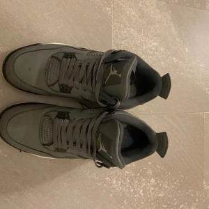 Grå Nike Air Jordans - Snygga grå Nike Air Jordans med klassisk design och snörning. Skorna har en vit sula och svarta detaljer, vilket ger en stilren look. Perfekta för sneaker-entusiaster.