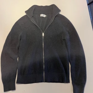 Grå tröja från East West - Säljer en snygg grå ribbad tröja från East West. Den har en dragkedja framtill och långa ärmar. Perfekt för höst och vinter, och den är supermjuk och bekväm. Passar både till vardags och lite finare tillfällen. Pricet är ej hugget i sten 🪨 skriv vid minsta fråga 😁😁