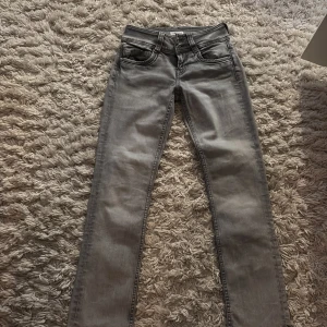 Grå jeans från Pepe Jeans - Säljer ett par grå jeans från Pepe Jeans i modellen Power Flex. De har en straight passform och midwaist, vilket gör dem både bekväma och stilrena. Perfekta för vardagsbruk och kan enkelt matchas med olika outfits. Skicket är mycket bra, nästan som nya!