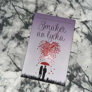 Smaker av lycka - Boken 'Smaker av lycka' av Nina Harrington och Kelly Hunter handlar om kärlek och relationer. Den har ett romantiskt omslag med silhuetter av ett par under ett paraply och hjärtan som regnar ner. Perfekt för dig som gillar romantiska berättelser med en twist av humor och värme.