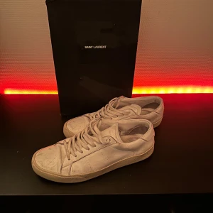 Saint Laurent sneakers - Schyssta Saint Laurent sneakers i strl 41. Omsulade en gång till nog deras mest klassiska sula. Lite skitiga på bilden men inga revor eller liknande. Rengör innan de skickas. Säljes då de tyvärr bara samlar damm nu för tiden.