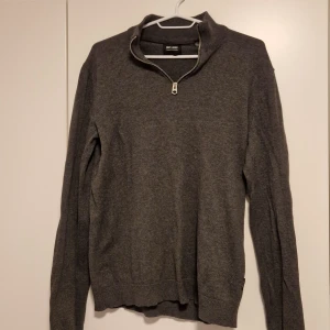 Grå tröja med dragkedja från Only & Sons - Säljer en stilren grå tröja från Only & Sons i storlek S. Tröjan har en praktisk dragkedja vid halsen och är perfekt för både vardag och fest. Materialet är mjukt och bekvämt, vilket gör den idealisk för höst och vinter. Passar bra till jeans eller chinos för en avslappnad look.