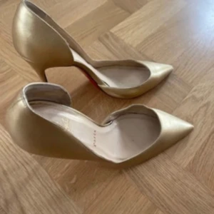 Guldiga pumps från Christian Louboutin - Christian louboutin Iriza 100cm Worn but went to the shoe maker and resoled with CL red bottoms and repainted in the same gold color costed 220euro 