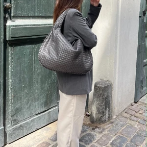 Grå flätad axelväska- Design by si - Säljer denna sjukt snygga väska ifrån design by si då den inte längre kommer till andvändning. Nypris 605 säljer för 375. Skriv privat för egna bilder❤️