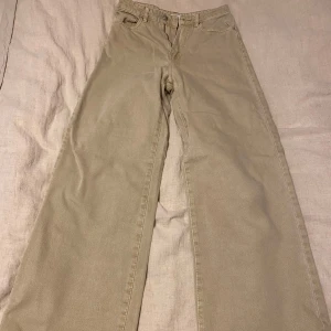 Beige jeans från Gina Tricot - Säljer ett par snygga beige jeans från Gina Tricot i storlek 34. De har en klassisk femficksdesign och är i ett mjukt och bekvämt material. Perfekta för både vardag och lite mer uppklädda tillfällen. Passformen är loose och de har en hög midja för en trendig look.