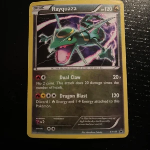 Rayquaza Pokémonkort - Säljer ett Rayquaza Pokémonkort med 120 HP. Kortet har attacker som Dual Claw och Dragon Blast. Det är en del av XY144-serien och har en gul ram med en bild av Rayquaza i mitten.