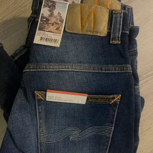 Blå jeans från Nudie Jeans w28L30 - Snygga blå jeans från Nudie Jeans i ekologisk bomull. De har en klassisk femficksdesign och en snygg tvättad look. Perfekta för en avslappnad stil.