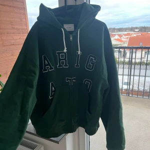 Axel Arigato hoodie - Säljer min gröna Axel Arigato ”legend zip hoodie” som aldrig används så tröjan är i nyskick, den är Inköpt för ca 3000kr på hemsidan, hör av dig om du vill ha fler bilder 😄