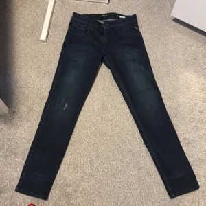 Mörkblå jeans från Replay - Snygga mörkblå jeans från Replay i modellen Anbass. De har en klassisk femficksdesign och dragkedja. Perfekta för en stilren look.