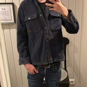 Mörkblå overshirt från H&M - Säljer en snygg mörkblå overshirt från H&M. Den har långa ärmar och praktiska bröstfickor med knappar. Perfekt som en overshirt. Tröjan är i storlek 152! Va inte rädd att höra av dig om du har några funderingar 💫👏