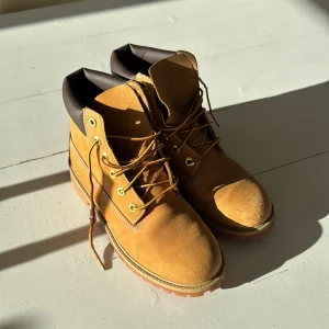 Timberlandboots med snörning - Knappt använda Timberland. Säljer ett par robusta bruna boots med snörning och kraftig sula. Perfekta för höst och vinter. De har en klassisk design med vadderad krage för extra komfort.