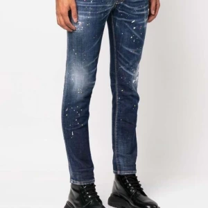 Jeans med färgstänk och slitningar - Snygga jeans med färgstänk och slitningar för en trendig look. Finns i olika nyanser av blått och grått. Perfekta för dig som vill ha en edgy stil. Passformen är slim och de har en klassisk dragkedja.   Storlek 50 och även 52 beroende på jeans 