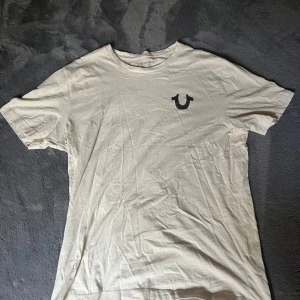 True religion T-shirt  - True t shirt köpt augusti 2024 på ASOS för 800kr använd 3 gånger i färgen beige super bra skick storlek XL