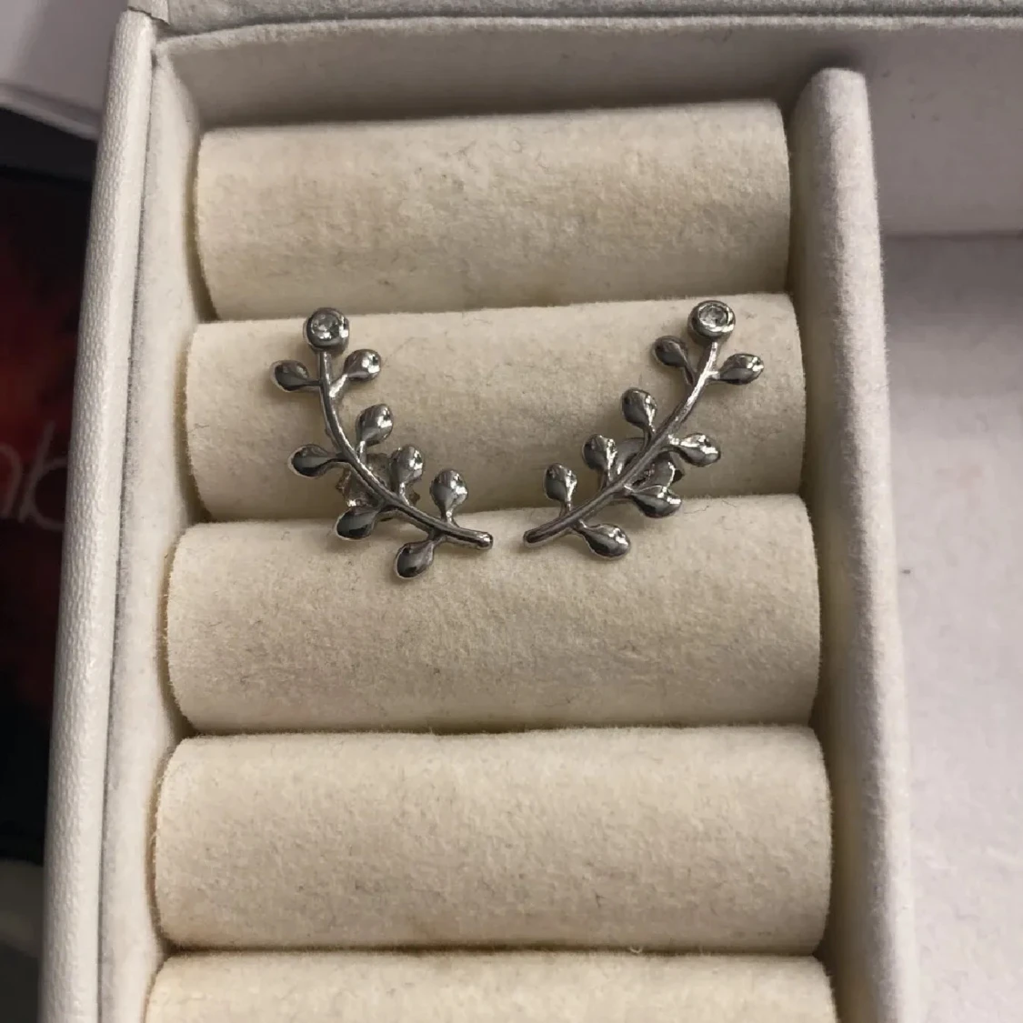 Silverfärgade örhängen med bladdetaljer