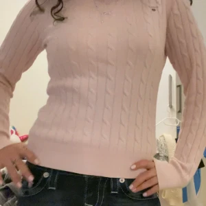 Rosa stickad tröja från Gant💗 - Säljer en snygg rosa stickad tröja från Gant med kabelstickat mönster. Tröjan har långa ärmar och en klassisk passform som passar perfekt till jeans. Perfekt för kyligare dagar! Storlek xs och finner inga slitningar💗💗