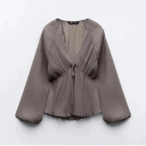 Blus Zara - Snygg grå blus från Zara med v-ringning och knytning framtill. Använt en gång och säljer då jag tröttnat på den.