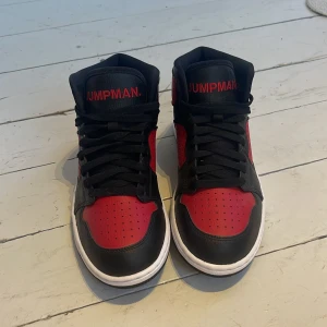 Jordan Jumpman - Snygga svarta och röda sneakers från Jordan med Jumpman klassisk design. Skorna har snörning och en vit sula som kontrasterar mot det svarta och röda lädret. Perfekta för en sportig look.