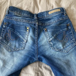 Blå jeans från Lab Industries - Snygga blå jeans från Lab Industries med coola detaljer på bakfickorna. De har ett litet hål på sidan men det syns knappt när man har på sig de, de är sydda till bootcut💗