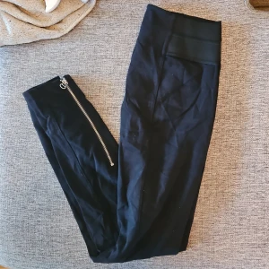 Svarta leggings med dragkedja - Snygga svarta leggings med en cool dragkedja längs sidan. Perfekta för en stilren look och bekväma att bära hela dagen. Passar bra till både sneakers och klackar.