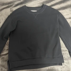 Svart tröja från KIDS ONLY - Säljer en svart tröja från KIDS ONLY i storlek 158. Tröjan har en klassisk design med rund hals och långa ärmar. Den är tillverkad i ett mjukt material som känns skönt mot huden. Perfekt för en avslappnad stil.