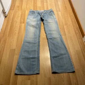 Lågmidjade bootcut jeans  - (19) De perfekta ljusblåa lågmidjade jeansen med snygga detaljer på fickorna, vingar inbroderade. Midjemått rakt över: 38, innerbenslängd: 85💕