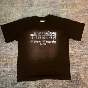 Maison Margiela Tshirt - Svart och blå Margiela T-shirt i toppskick | Tröjan är knappt använd och har inga defekter eller syn på användning, nyskick | Storlek S (passar oversized)