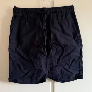 Svarta shorts från H&M - Snygga svarta shorts från H&M i relaxed fit. Perfekta för en avslappnad stil med elastisk midja för extra komfort. De har en enkel design utan onödiga detaljer, vilket gör dem lätta att matcha med olika outfits.