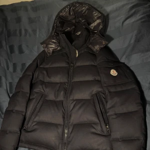 Mörkblå Moncler montegenevre - Säljer denna snygga moncler montegenevre för ett väldigt bra pris, ena dragkedjan på jackan är utbytt och den har någon defekt men annars i bra skick, den är såklart äkte skriv för mer information/bilder 