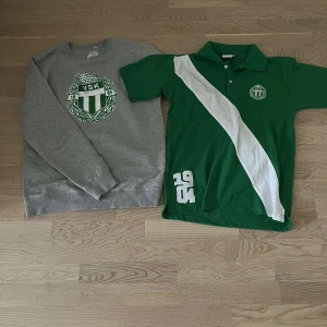 Grå sweatshirt och grön pikétröja - Säljer en grå sweatshirt med ett stort tryck på bröstet och en grön pikétröja med vit diagonal rand och tryck. Sweatshirten har långa ärmar och pikétröjan har korta ärmar. Perfekt för sportiga tillfällen eller vardagsbruk.