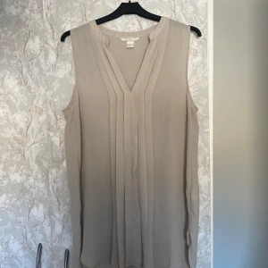 Beige tunika/blus från H&M - Helt oanvänd. Väldigt bra skick. Jätte skönt material.