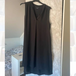 Svart tunika från Gina Tricot - Sommar tunika från Gina Tricot. Jätte skönt material. Super att ha över badkläder på sommaren eller bara gå runt på stranden. Inte använd många gånger en väldigt liten fläck på sidan från saltvatten men annars är den som ny.