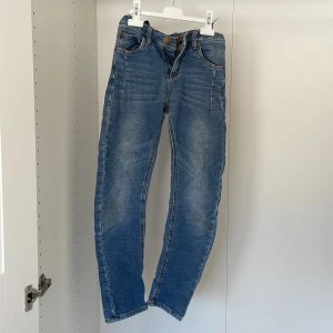 Blå jeans från Lab Industries - Säljer ett par snygga blå jeans från Lab Industries. De har en klassisk femficksdesign och en knappgylf. Perfekta för en avslappnad stil.