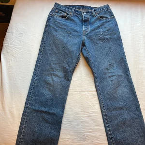 Levi's 501 jeans - Säljer dessa custom Levis jeansen. Hemmagjorda slitningar som ger den Klassiska blå Levi's 501 jeans med rak passform. Tillverkade i slitstarkt denim med knappgylf. Perfekta för en tidlös stil. 
